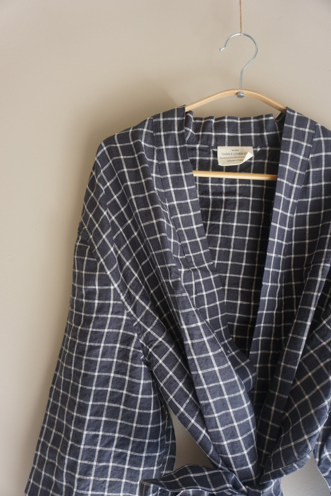 Simple Linen Co. Close up view of hanging 100% French Flax linen dressing gown in Navy Grid.