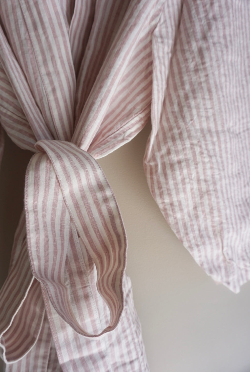 A close up detailed view of Simple Linen Co's Pink Stripe dressing gown, made from 100% french flax linen.