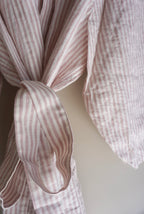 A close up detailed view of Simple Linen Co's Pink Stripe dressing gown, made from 100% french flax linen.