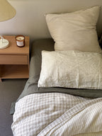 Simple Linen Co. 100% French flax linen sheet set in Khaki, featured with Elowyn dove grey gingham and olive pinstripe double sided duvet cover set, top down view in minimalistic bedroom.