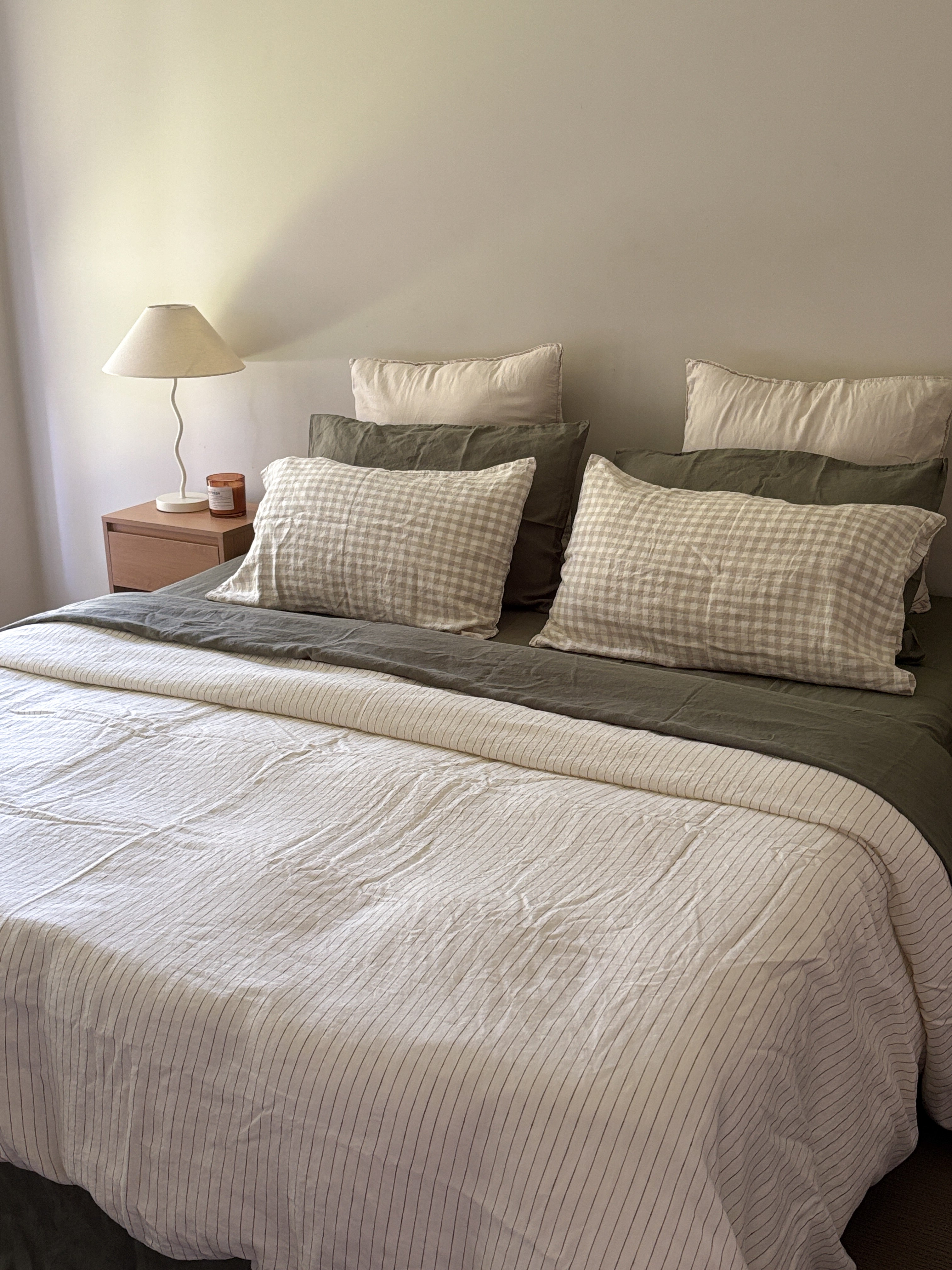 Simple Linen Co. 100% French flax linen double sided duvet cover Elowyn in Olive pinstripe and dove grey gingham, paired with Khaki sheet set, in a minimalist bedroom setting.  Stonewashed for softness and breathable year-round comfort.