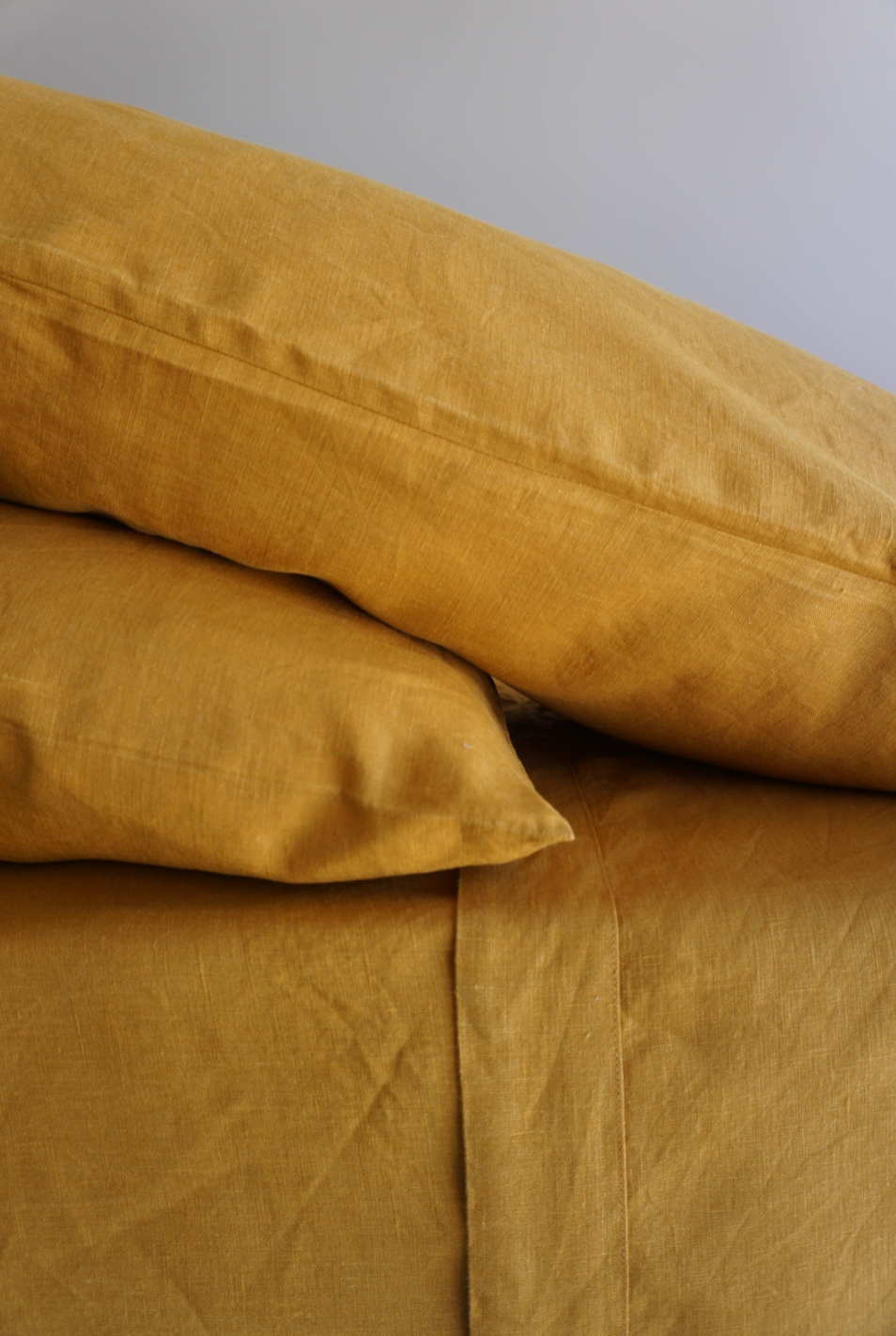 Simple Linen Co. 100% French flax linen sheet set in Mustard, stonewashed for added softness and durability, sheet set includes pillowcases, flat sheet and fitted sheet, sustainably packaged in reusable linen drawstring bag.