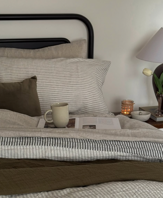 Simple Linen Co. 100% French flax linen sheet set in Nature, featuring Ida Duvet Cover with a double pinstripe and charcoal stripe, in cozy wintery bedroom setting.